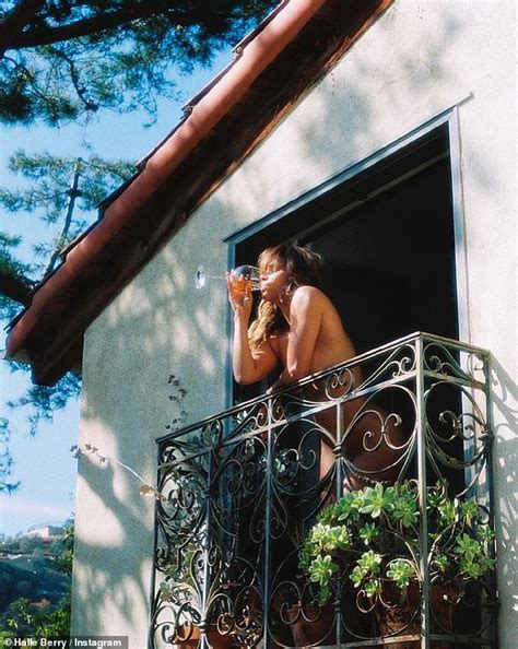 Halle Berry, 56, poses NUDE on a balcony as she sips from a。